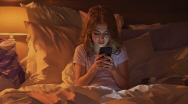 メッセージを送るか迷ってスマホを見つめる女性